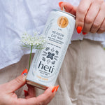 Person holding Heti CBD & THC mocktail beverage can in flavor Meadow Cat Nap which is dandelion leaf, lemon balm and wild mint