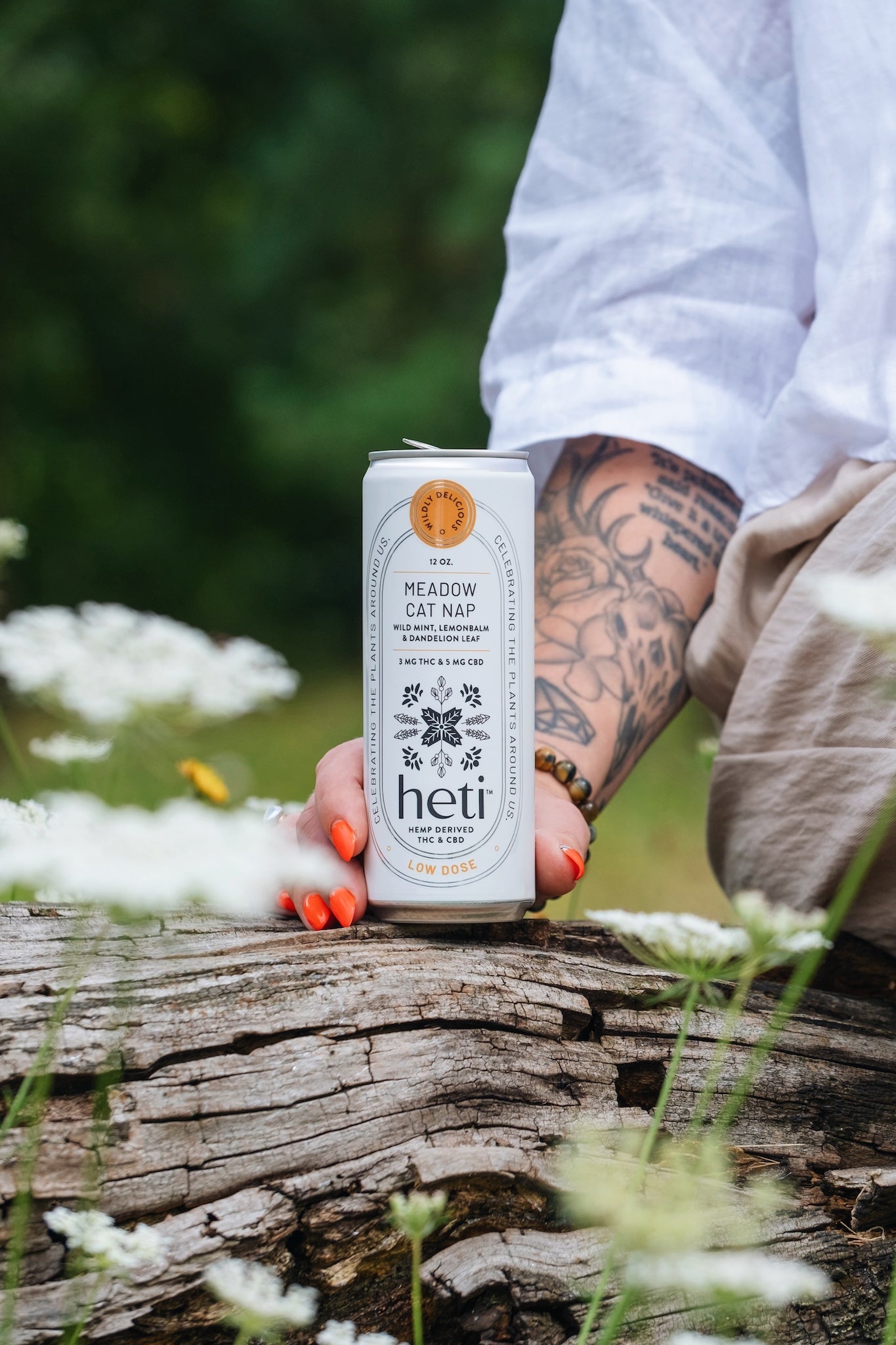 Person holding a Heti CBD & THC mocktail beverage can in flavor Meadow Cat Nap which is dandelion leaf, lemon balm and wild mint