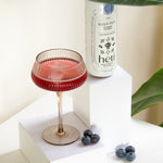 River Path low-dose THC and CBD drink by Heti with blueberry and rosehip, served as a mocktail with fresh blueberries.