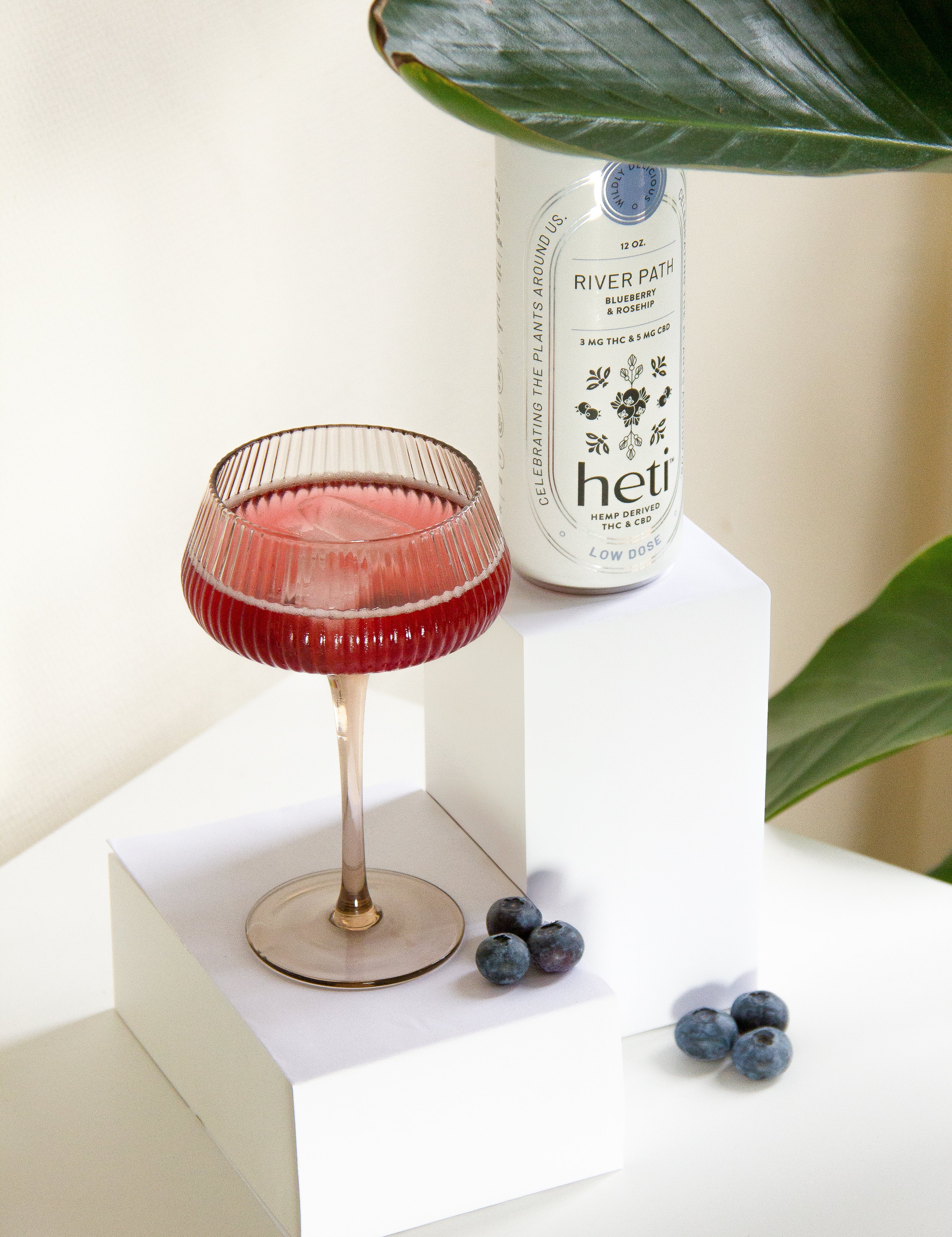 River Path low-dose THC and CBD drink by Heti with blueberry and rosehip, served as a mocktail with fresh blueberries.