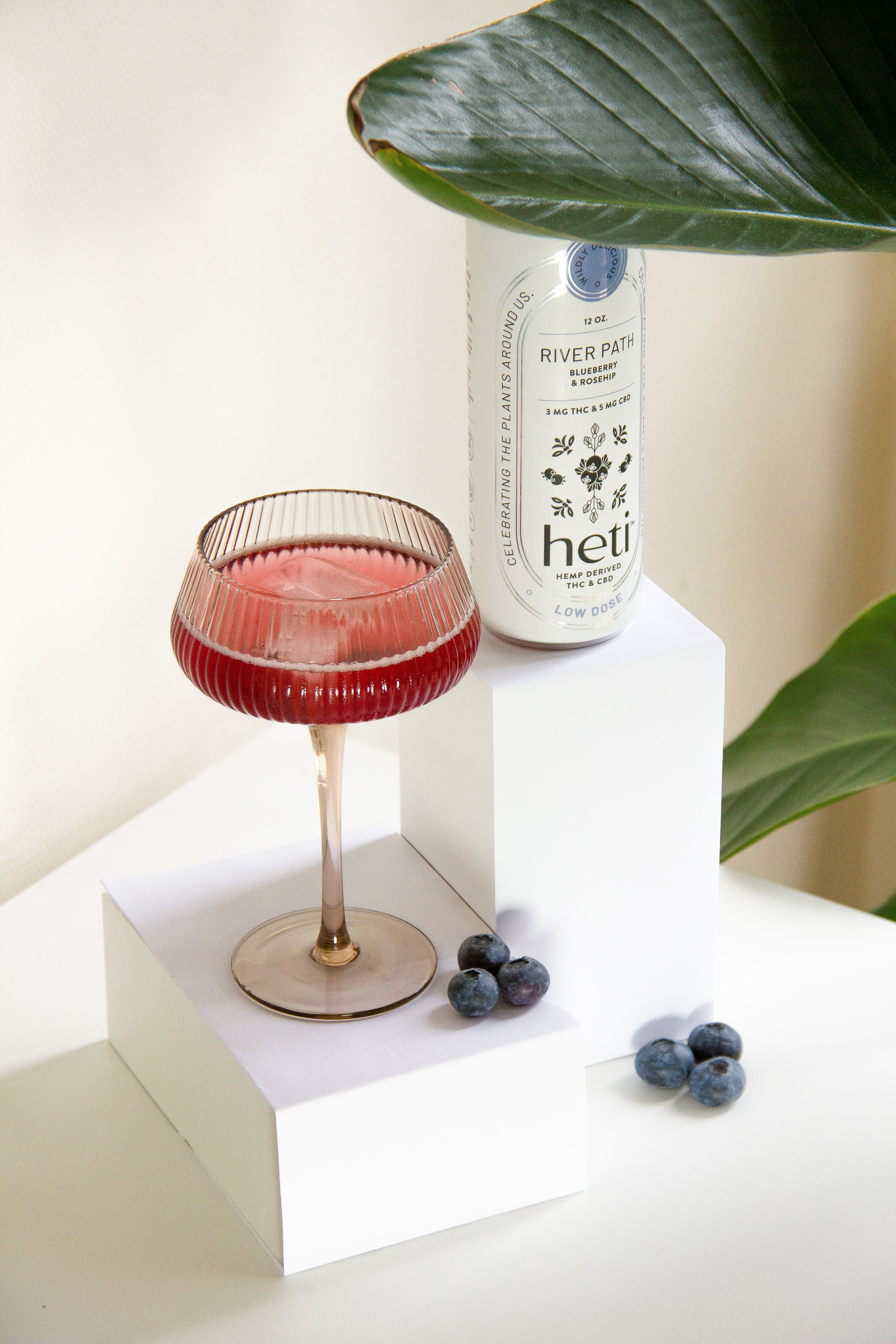 River Path low-dose THC and CBD drink by Heti with blueberry and rosehip, served as a mocktail with fresh blueberries.