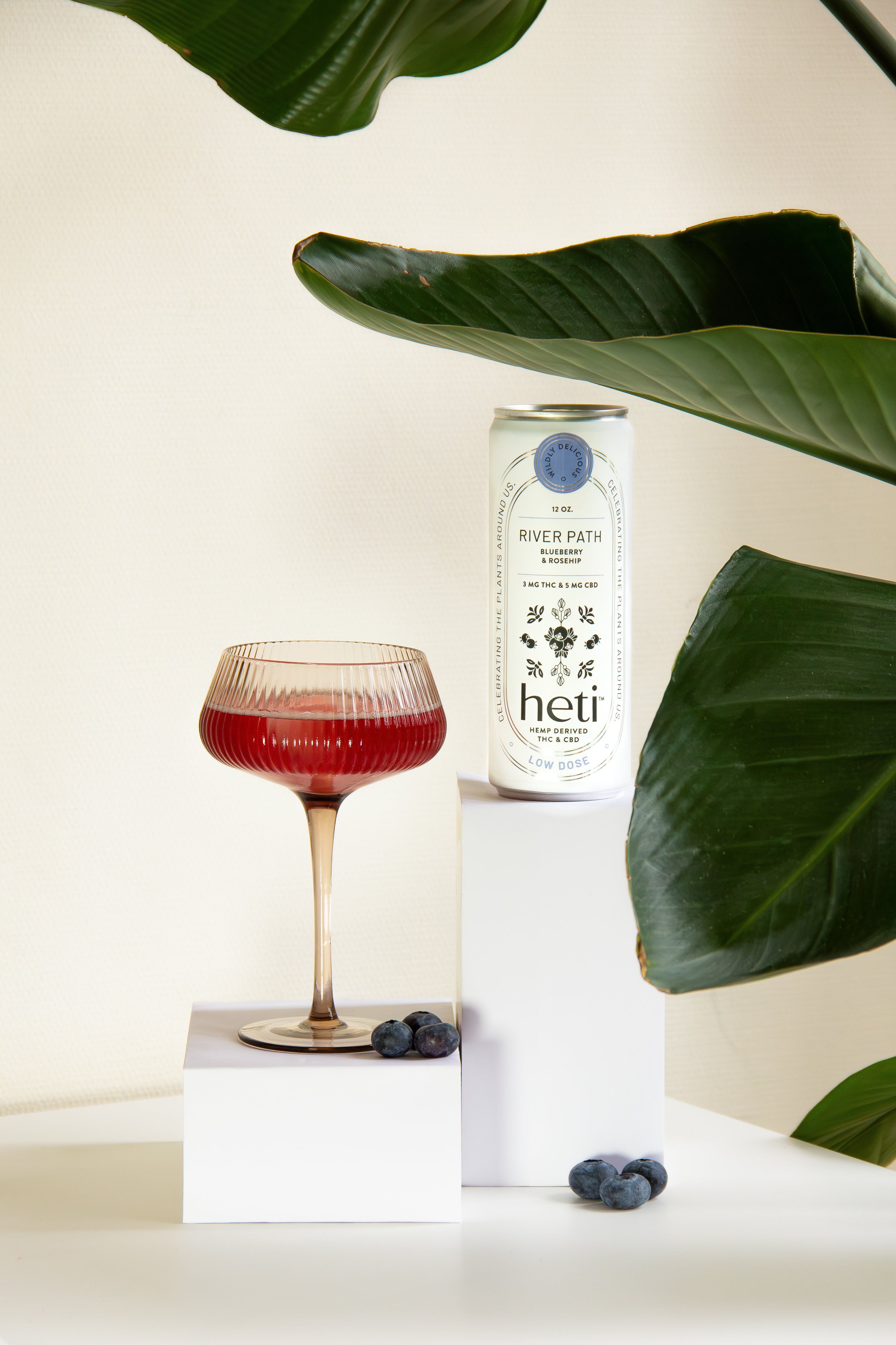 River Path low-dose THC and CBD drink by Heti with blueberry and rosehip, served as a mocktail with fresh blueberries.