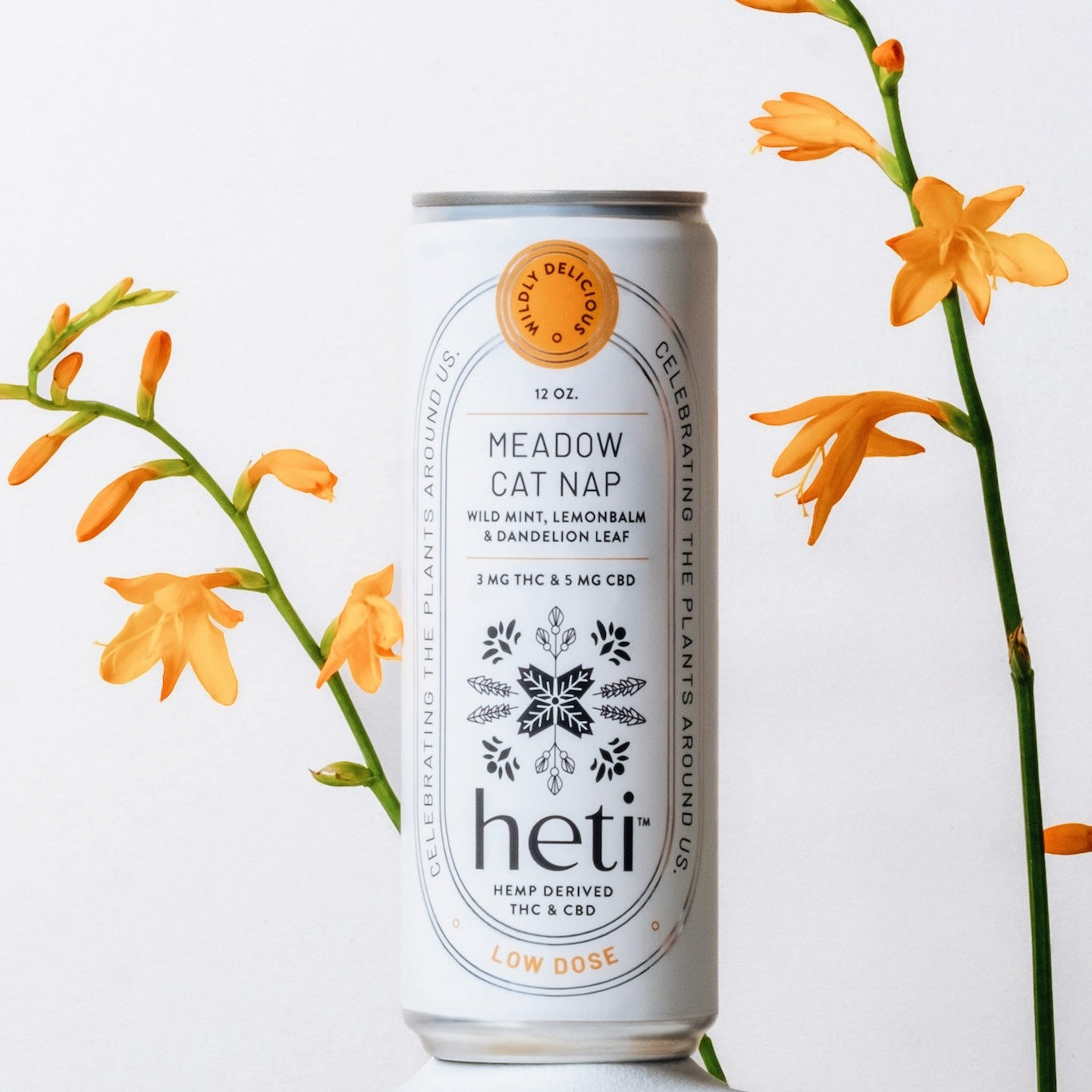 Meadow Cat Nap Heti THC Seltzer Displayed With Yellow and Orange Plants. Made With lemonbalm, wild mint, and dandelion leaf