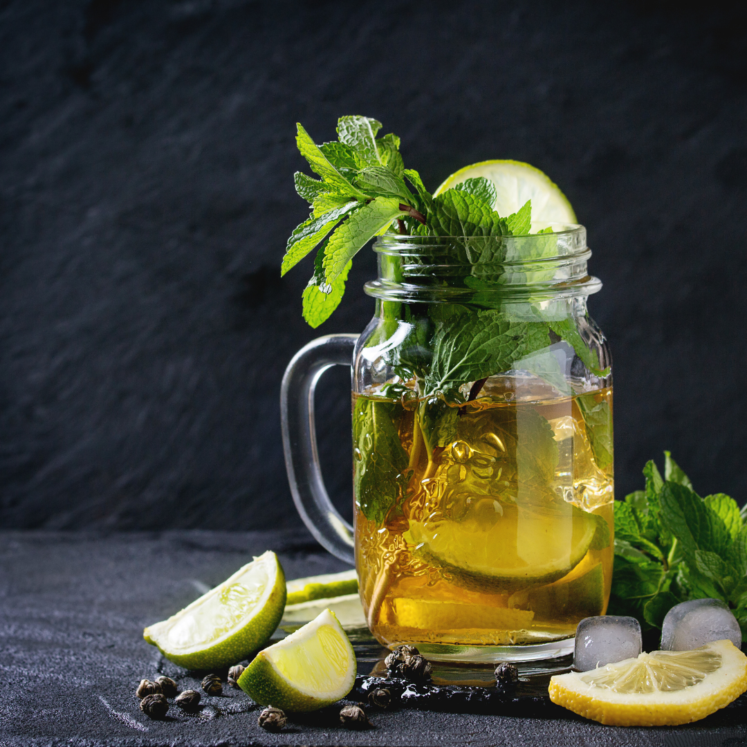 Woodland Green Tea Cooler mocktail with lemon and thyme, made with Heti’s Woodland Edge beverage, served over ice on a late summer afternoon