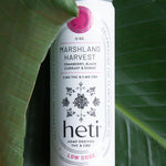 Low-dose THC and CBD drink Marshland Harvest by Heti with cranberry and black currant, styled on tropical leaves