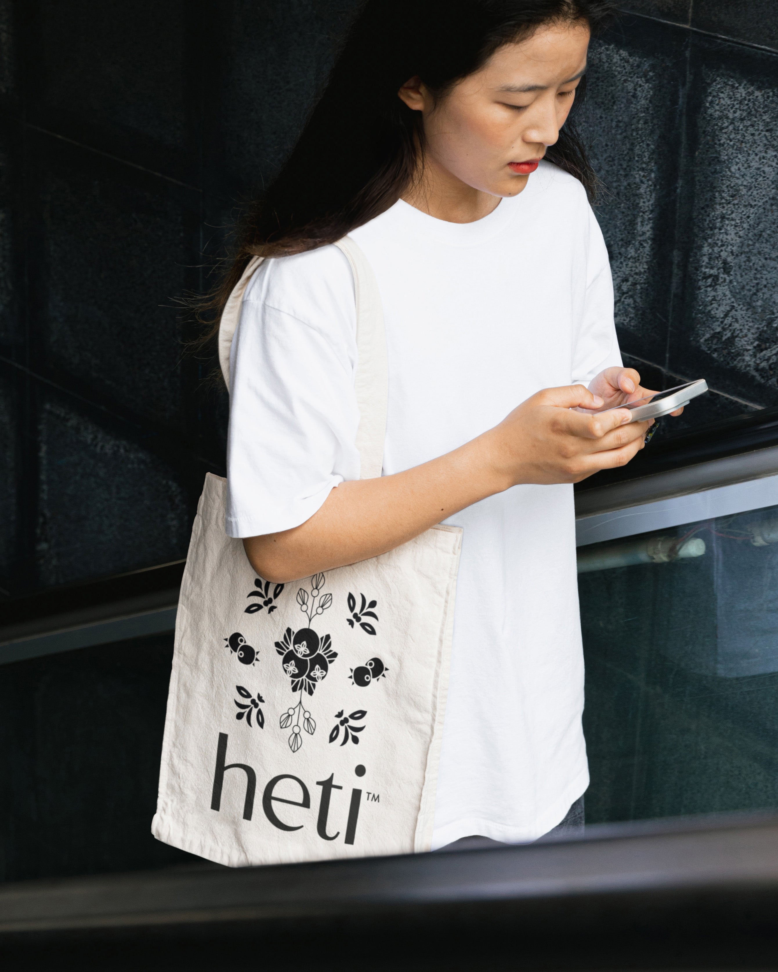 Merchandise image of THC beverage Heti, woman wearing Heti reusable fabric shopping bag